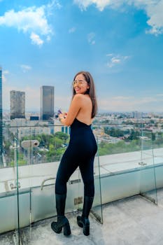 Model posing on a rooftop with a stunning view of Ciudad de México skyline.