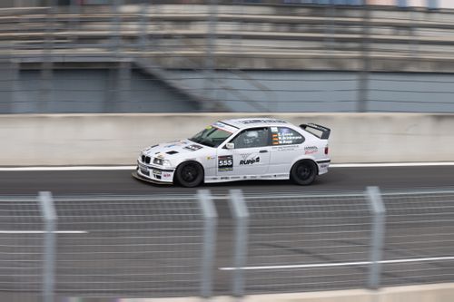 Free Car speeding on a racetrack, showcasing motorsport excitement and dynamic motion blur. Stock Photo