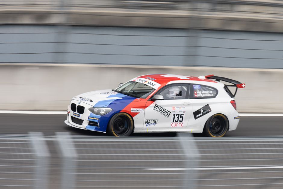 Dynamic shot of a racing car speeding on a track, showcasing vibrant colors and motion.
