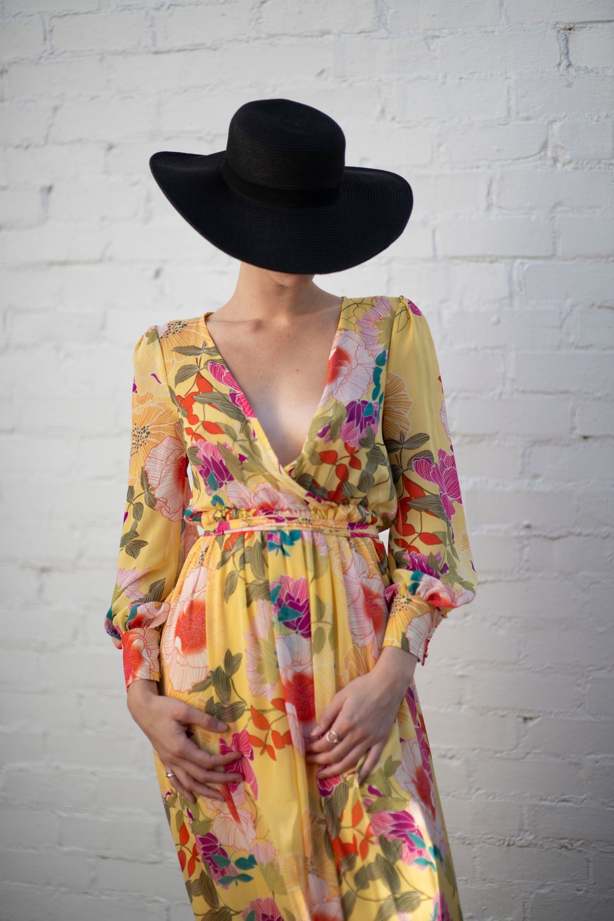 A model in a garden in floral print, the bold tropical floral in its element