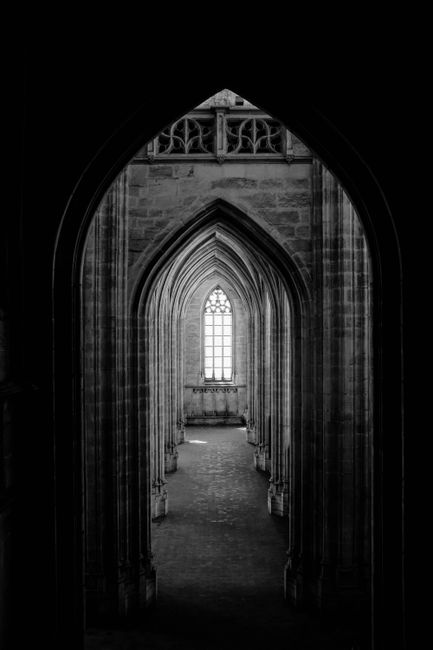 Dramatic black and white photo of a gothic archway with intricate architectural details.