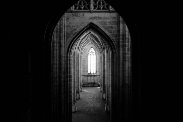 Gothic stone archway in low light — photo by Adrien Olichon on Pexels