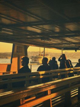 People on a ferry enjoying a scenic sunset view of the city and waterways.