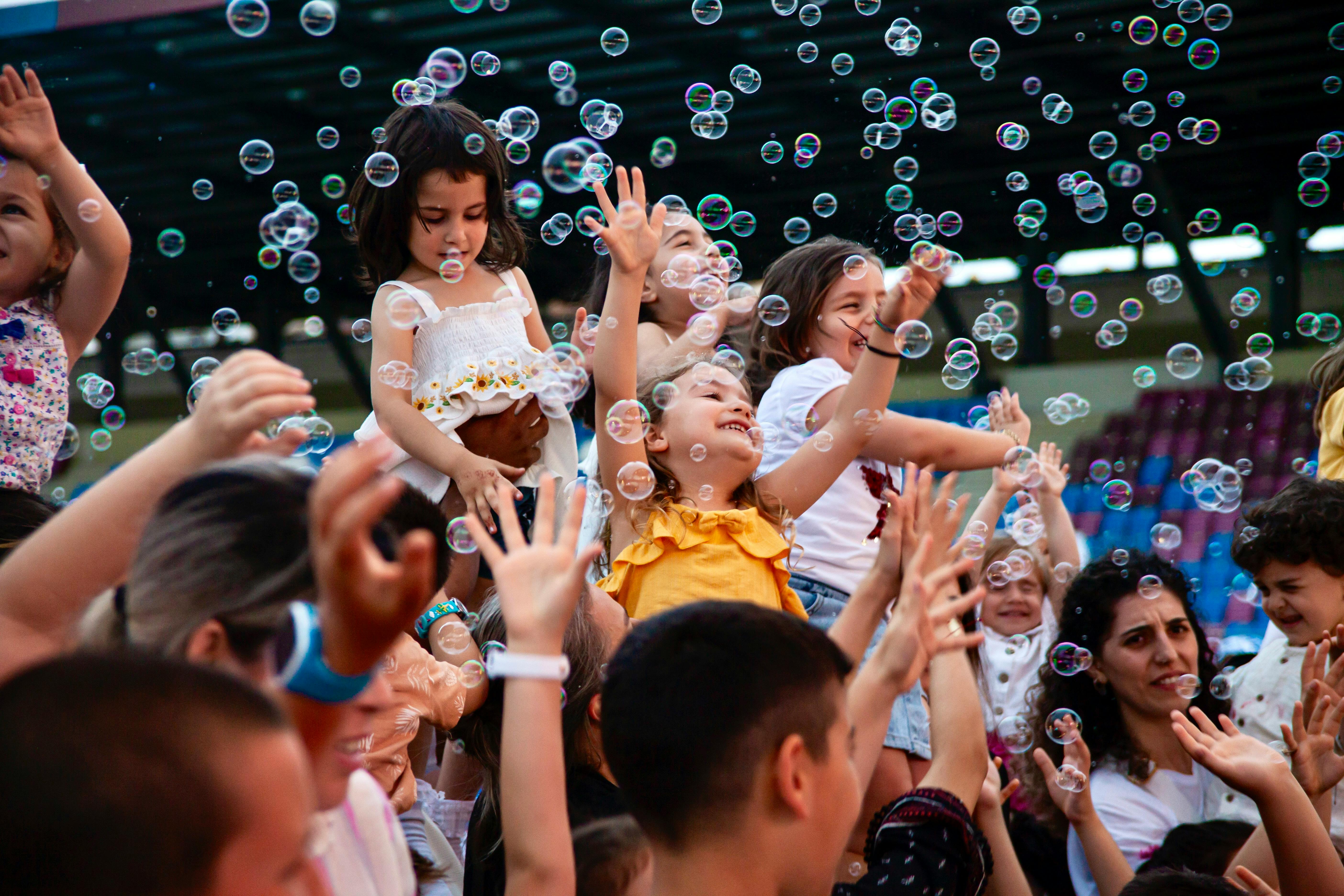 children playing with bubbles at a festival