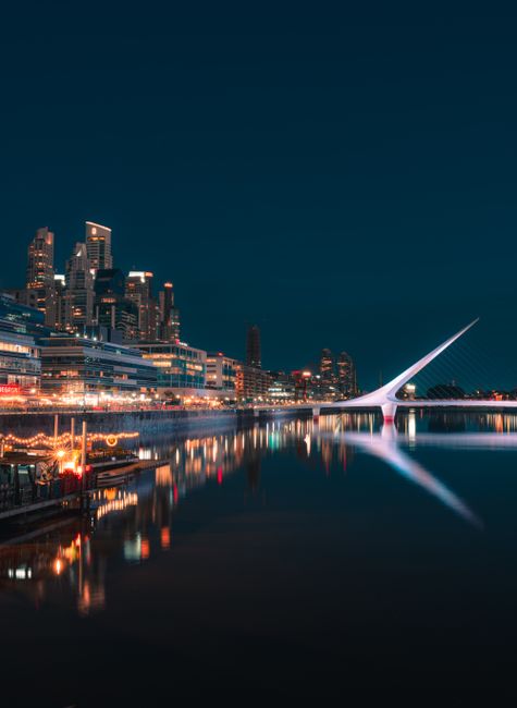 Stunning cityscape of Buenos Aires featuring the illuminated Puente de la Mujer at night.