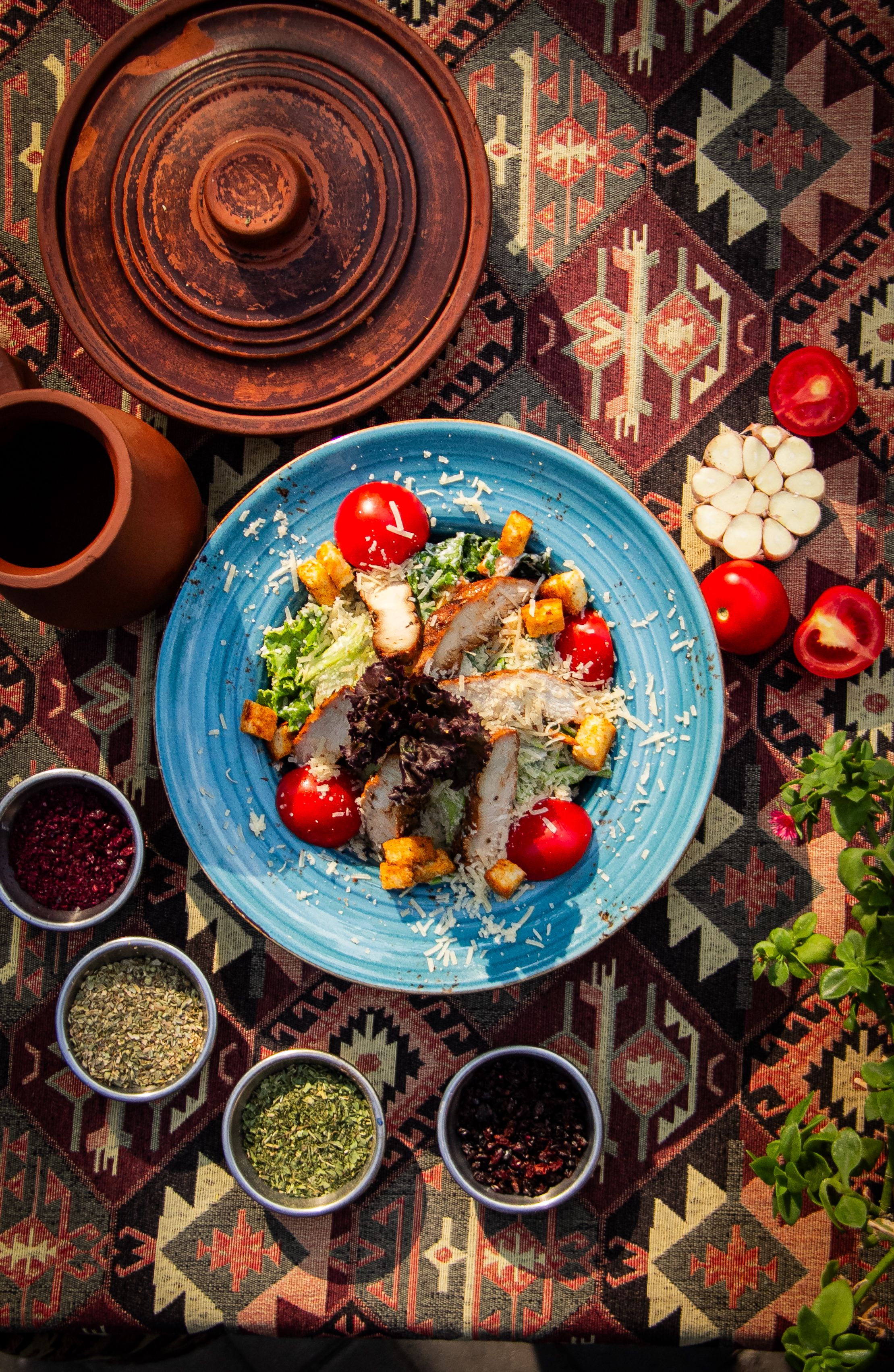 Vibrant Mediterranean salad with fresh veggies and spices on a traditional textile backdrop.