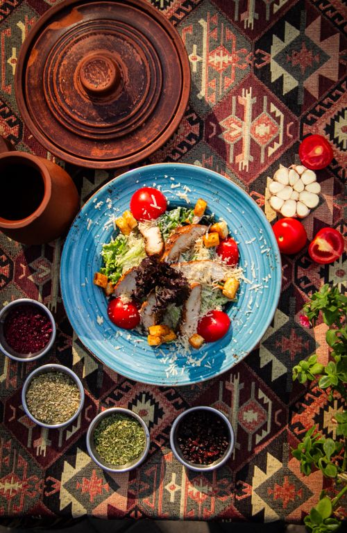 Free Vibrant Mediterranean salad with fresh veggies and spices on a traditional textile backdrop. Stock Photo
