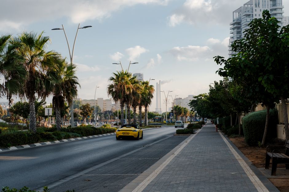 Cars parked on a street in Tel Aviv, Israel with blue and white curb markings
