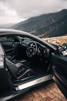 Elegant sports car interior against a scenic mountain backdrop, showcasing luxury and performance.