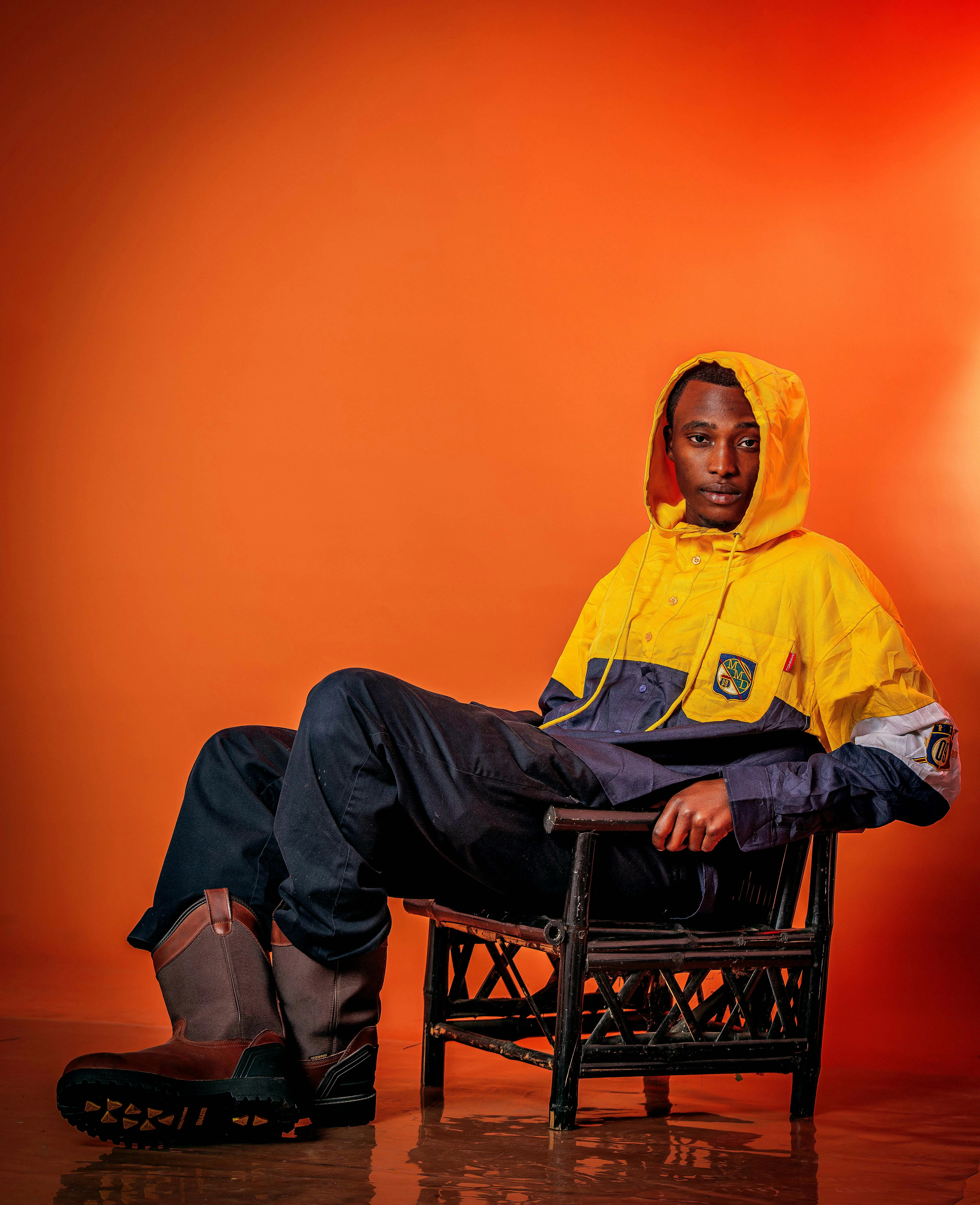 a man in a yellow jacket sitting on a chair