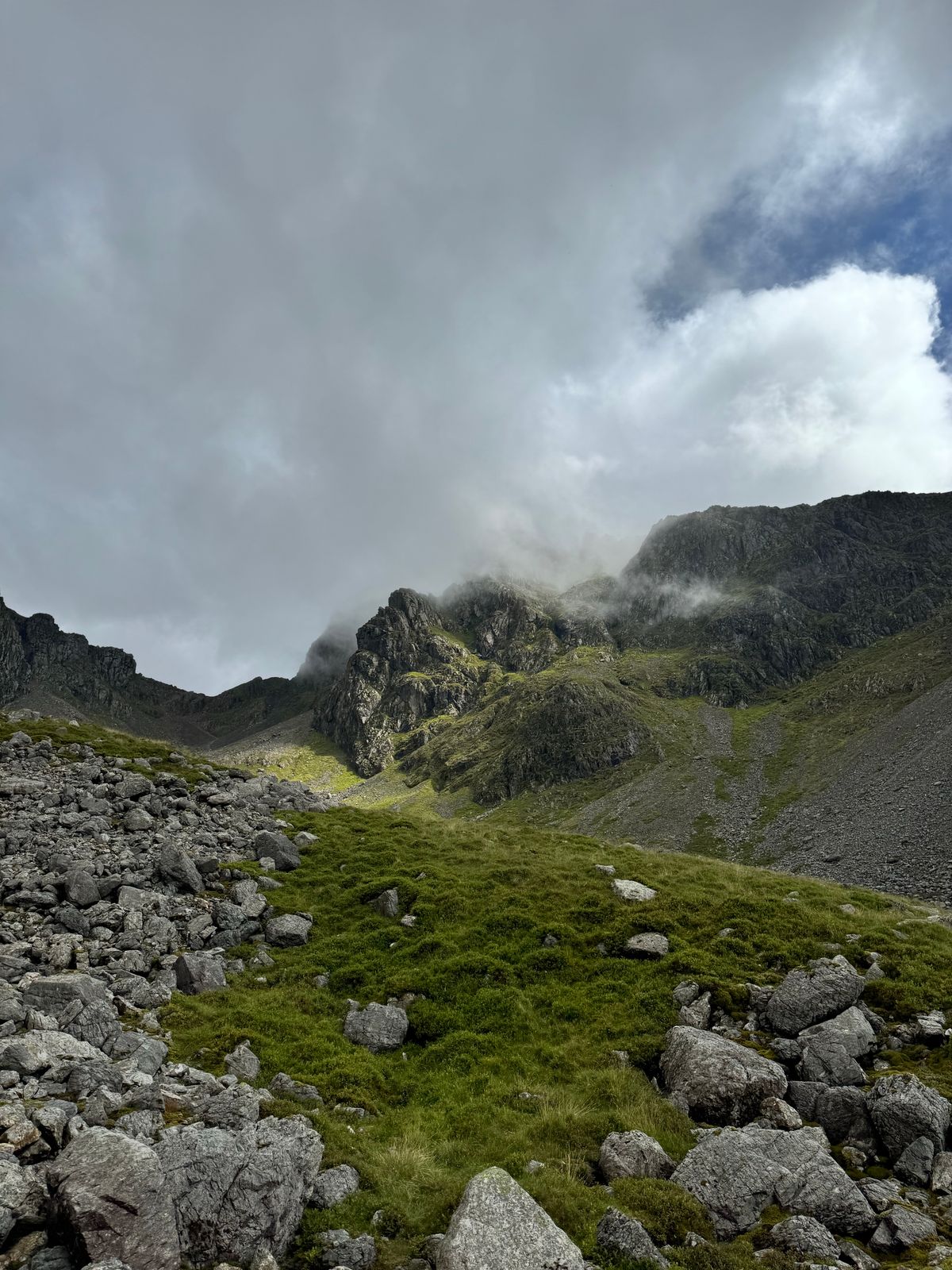 Mist drifting over dark crags and boulders on Scafell.