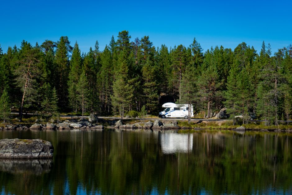 Traveler enjoying a Finnish summer lake, with insect repellent visible, emphasizing summer essentials