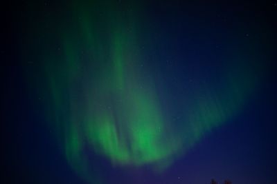 Green aurora over a dark ridge — photo by Oliver Schroder on Pexels