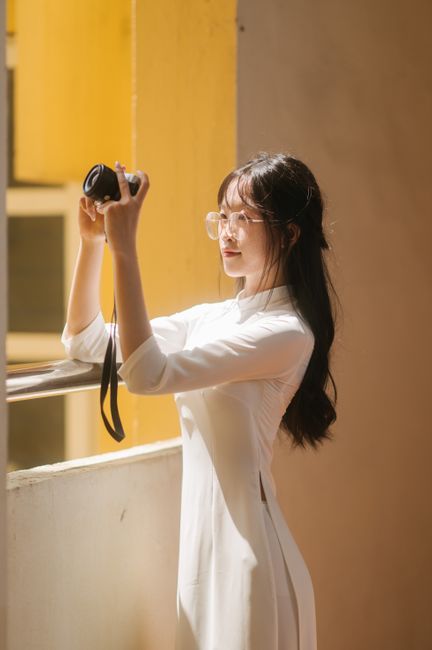 Captivating portrait of a woman in Lạng Sơn, Vietnam, capturing moments with her camera indoor.