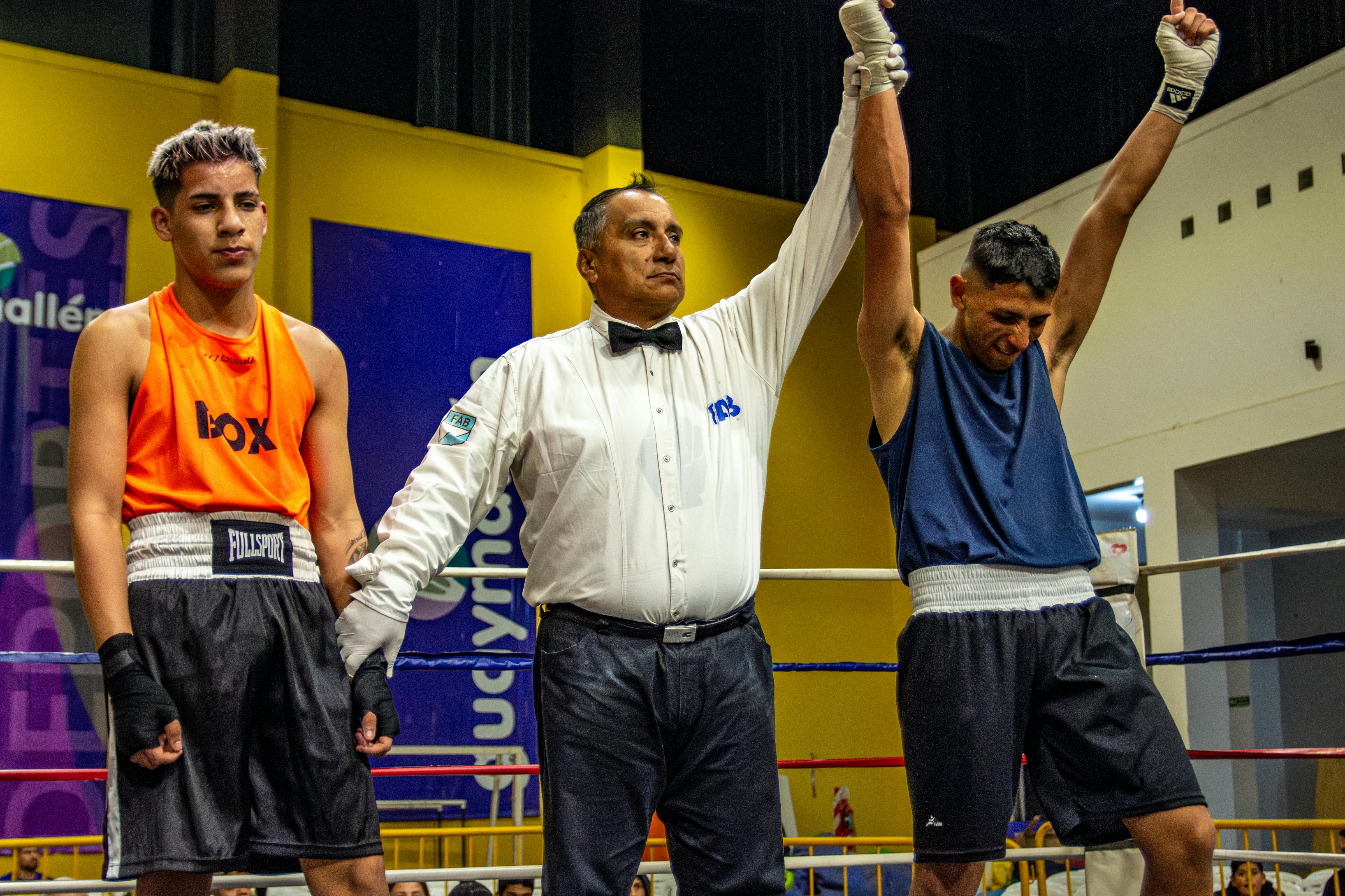 A referee declares the winner of a boxing match as one boxer