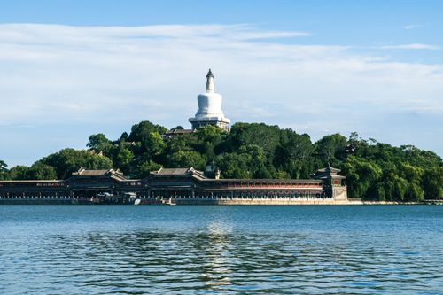 Free Scenic view of the iconic White Pagoda in Beihai Park, Beijing, with surrounding greenery and water. Stock Photo