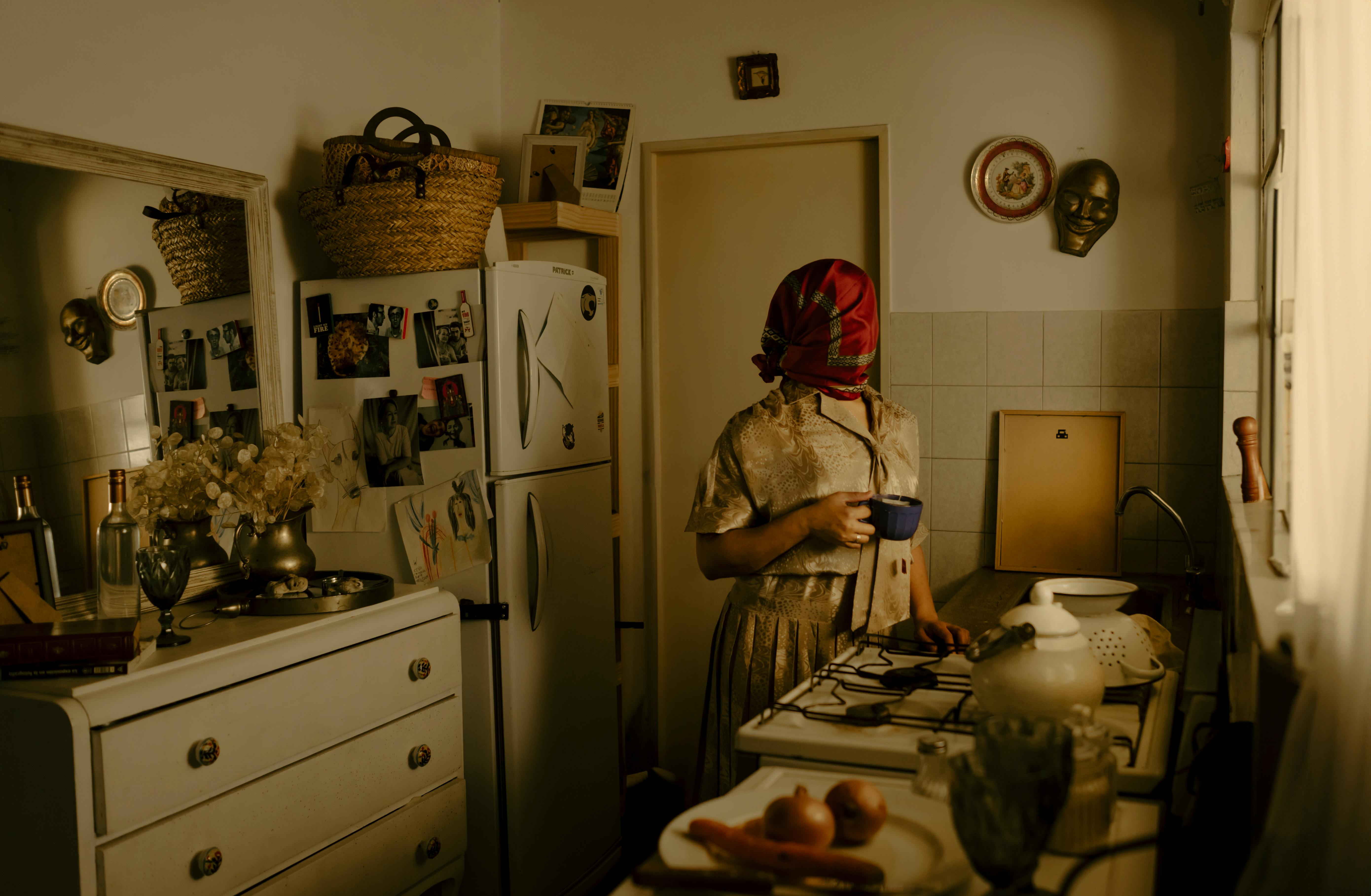 a woman in a kitchen with a red head scarf