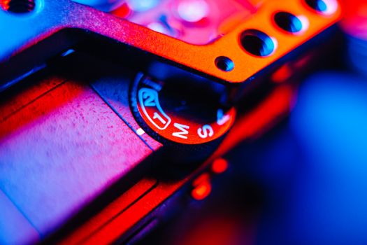 Vibrant close-up of camera equipment highlighted by blue and red LED lighting.