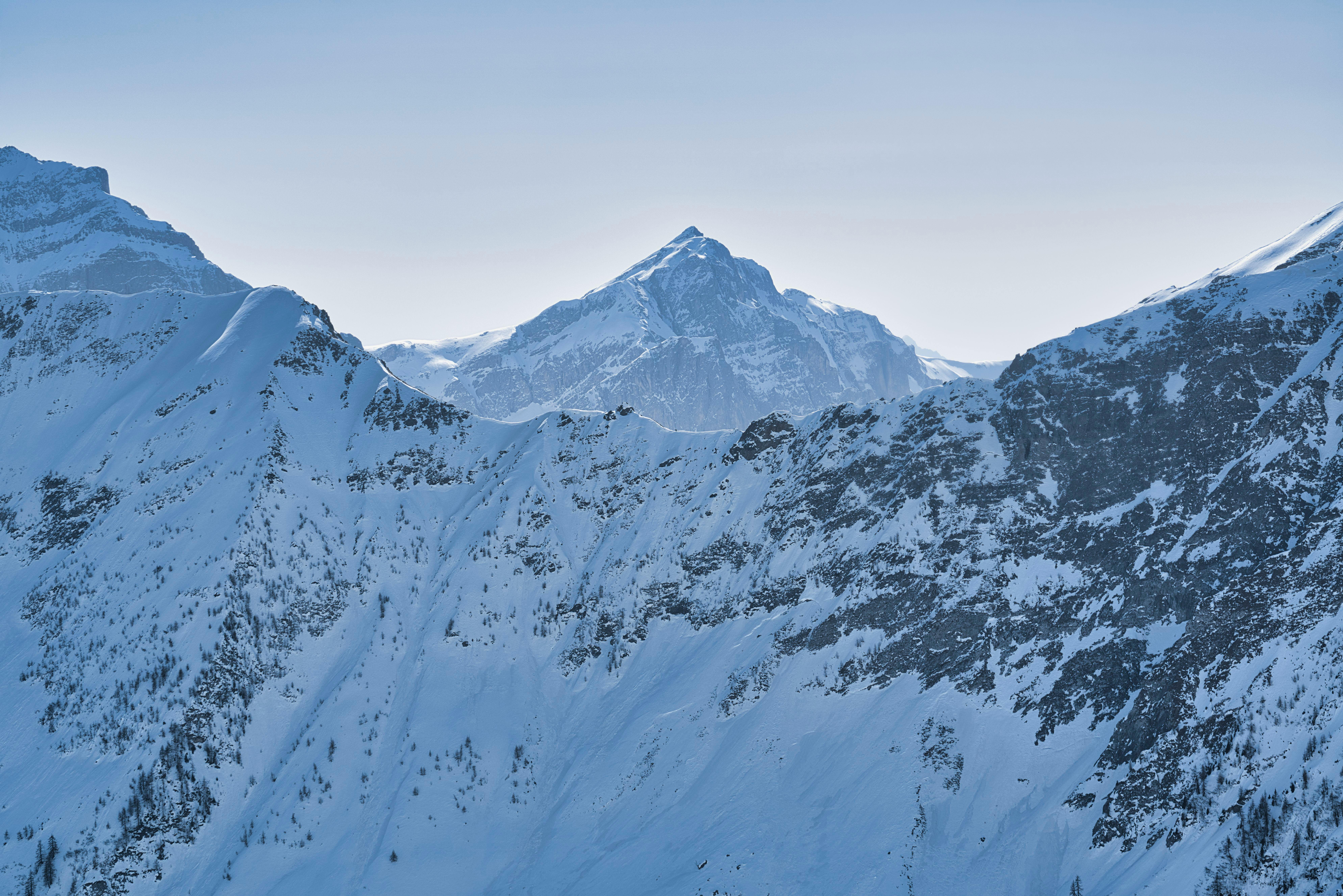 Majestic snowy mountain peaks under a clear winter sky, offering a serene alpine vista.