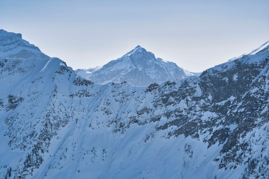Majestic snowy mountain peaks under a clear winter sky, offering a serene alpine vista.