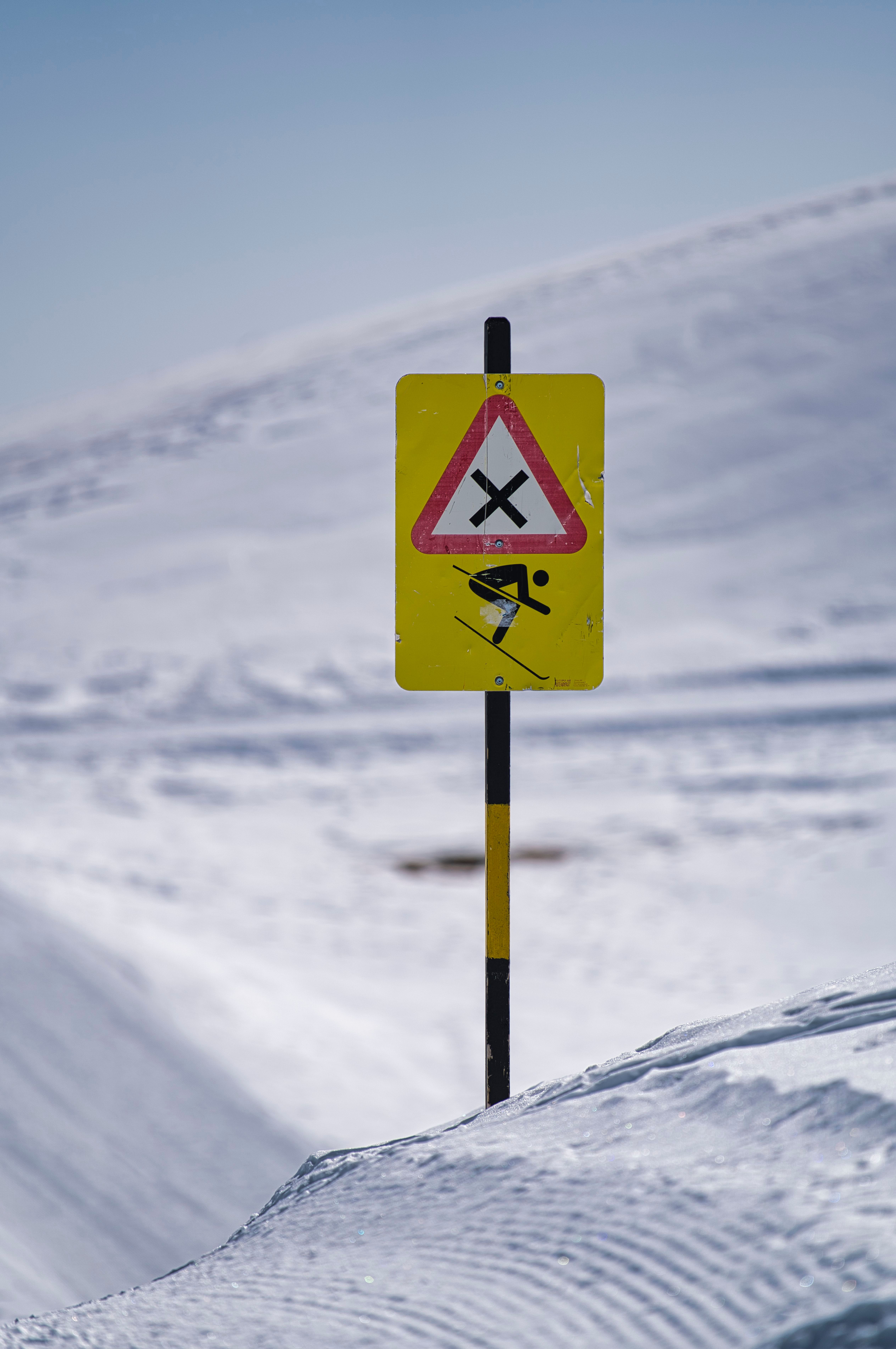 A sign warning of a snow covered road · Free Stock Photo