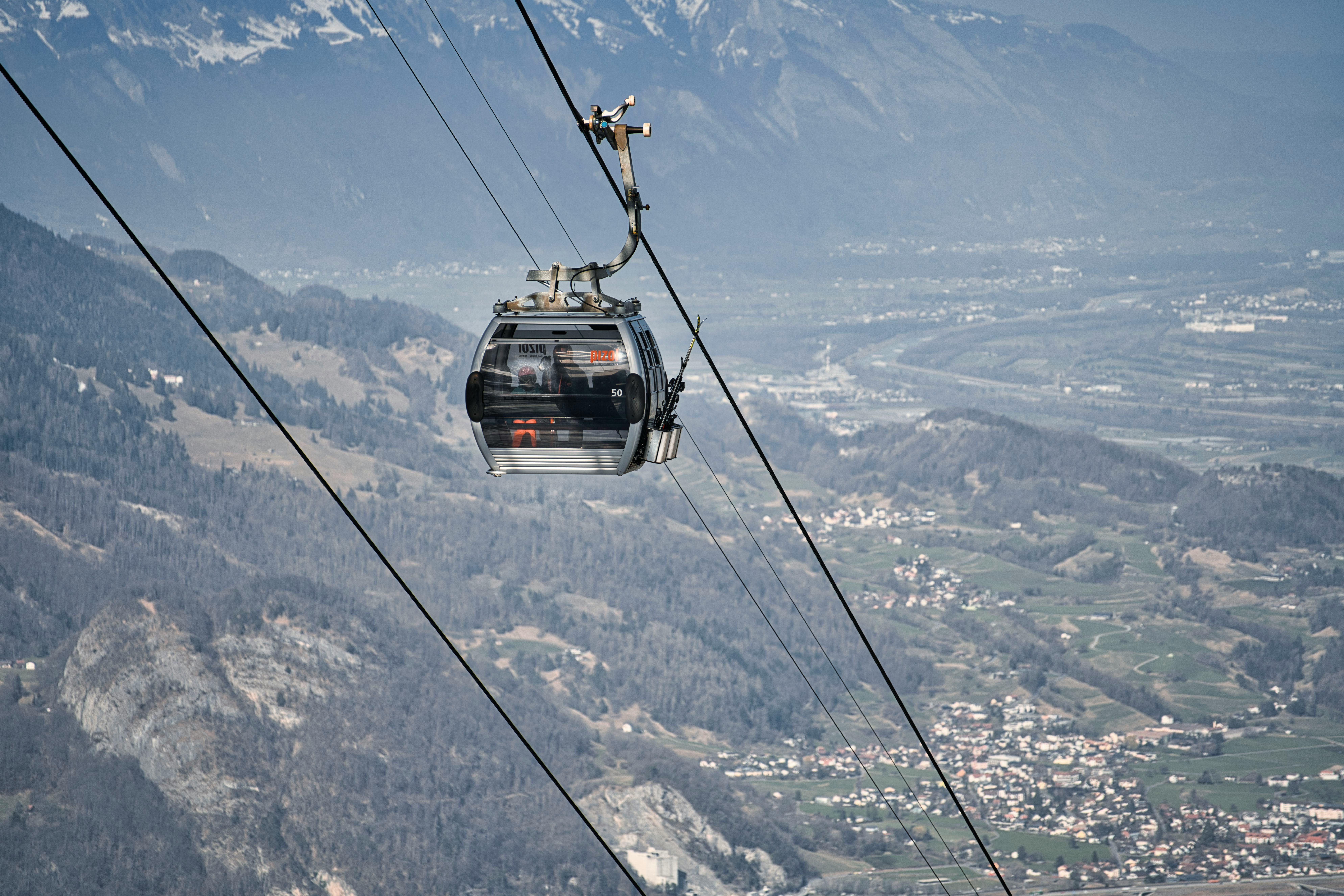 Prescription Goggle Inserts - View from above of a cable car traversing snowy alpine scenery, perfect for winter travel enthusiasts.