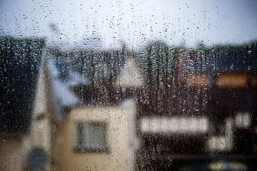 Blurred view of a rainy day in Bournemouth, capturing raindrops on a window.