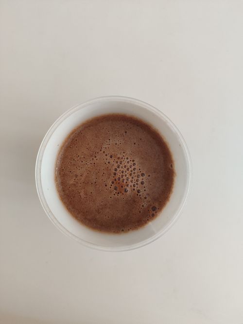 Free Delicious frothy hot chocolate in a white cup on a minimalistic background, perfect for cozy moments. Stock Photo
