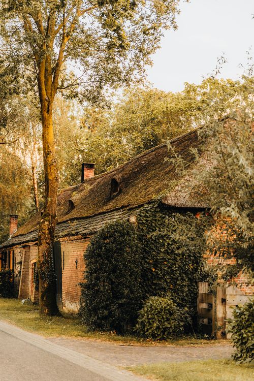 Free A warm, rustic brick house surrounded by autumn foliage in a peaceful country setting. Stock Photo
