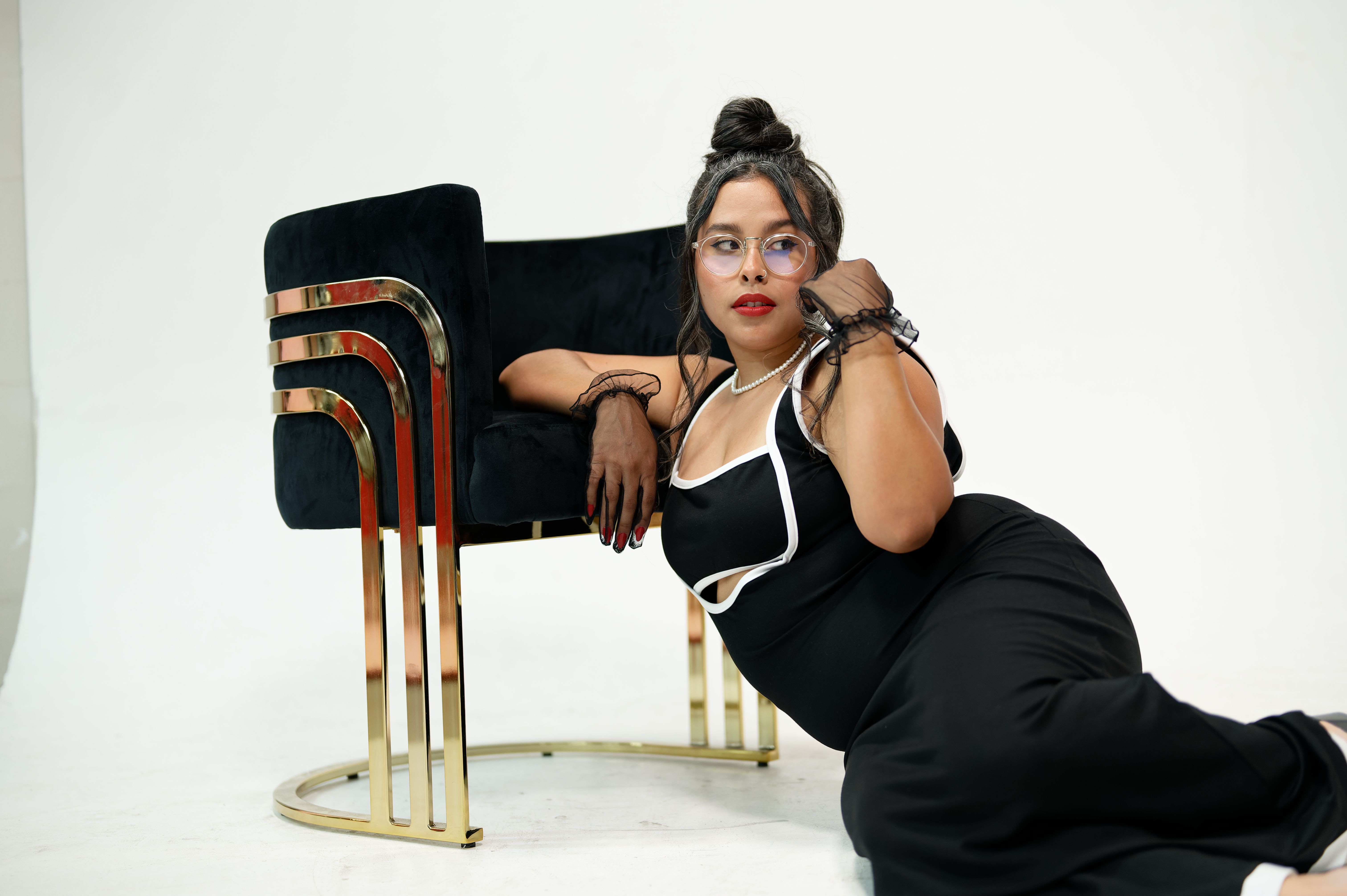 A woman in a black dress and black shoes sitting on a chair · Free ...