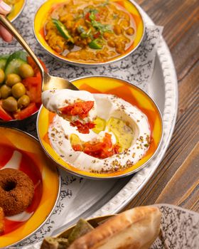 A colorful Middle Eastern mezze platter featuring hummus, falafel, and pickled vegetables.