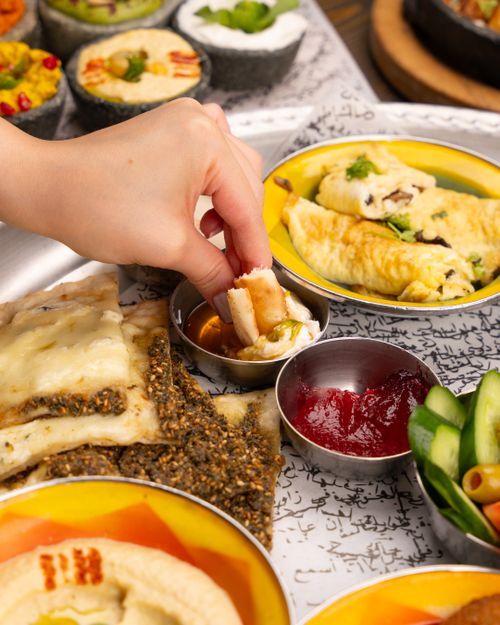 Free A variety of Middle Eastern dishes with bread, dips, and a hand serving food. Stock Photo