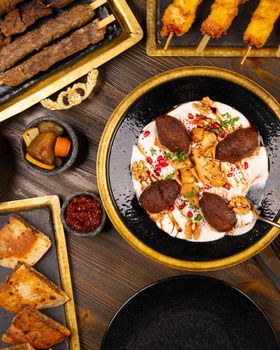 Delicious assortment of Middle Eastern dishes featuring spiced meats, dips, and pita bread on a rustic table.