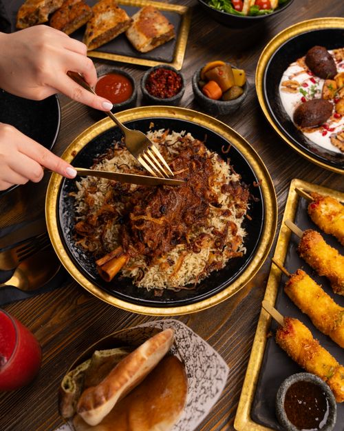 Free A delicious Middle Eastern meal featuring spiced rice, kebabs, and traditional sides. Stock Photo