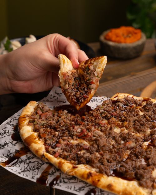 Free Savory Middle Eastern lahmacun pizza topped with minced meat, perfect for lunch or dinner. Stock Photo