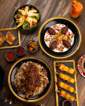 A delightful spread of Middle Eastern dishes including kibbeh, rice pilaf, and fresh salad, perfect for a luxurious meal.