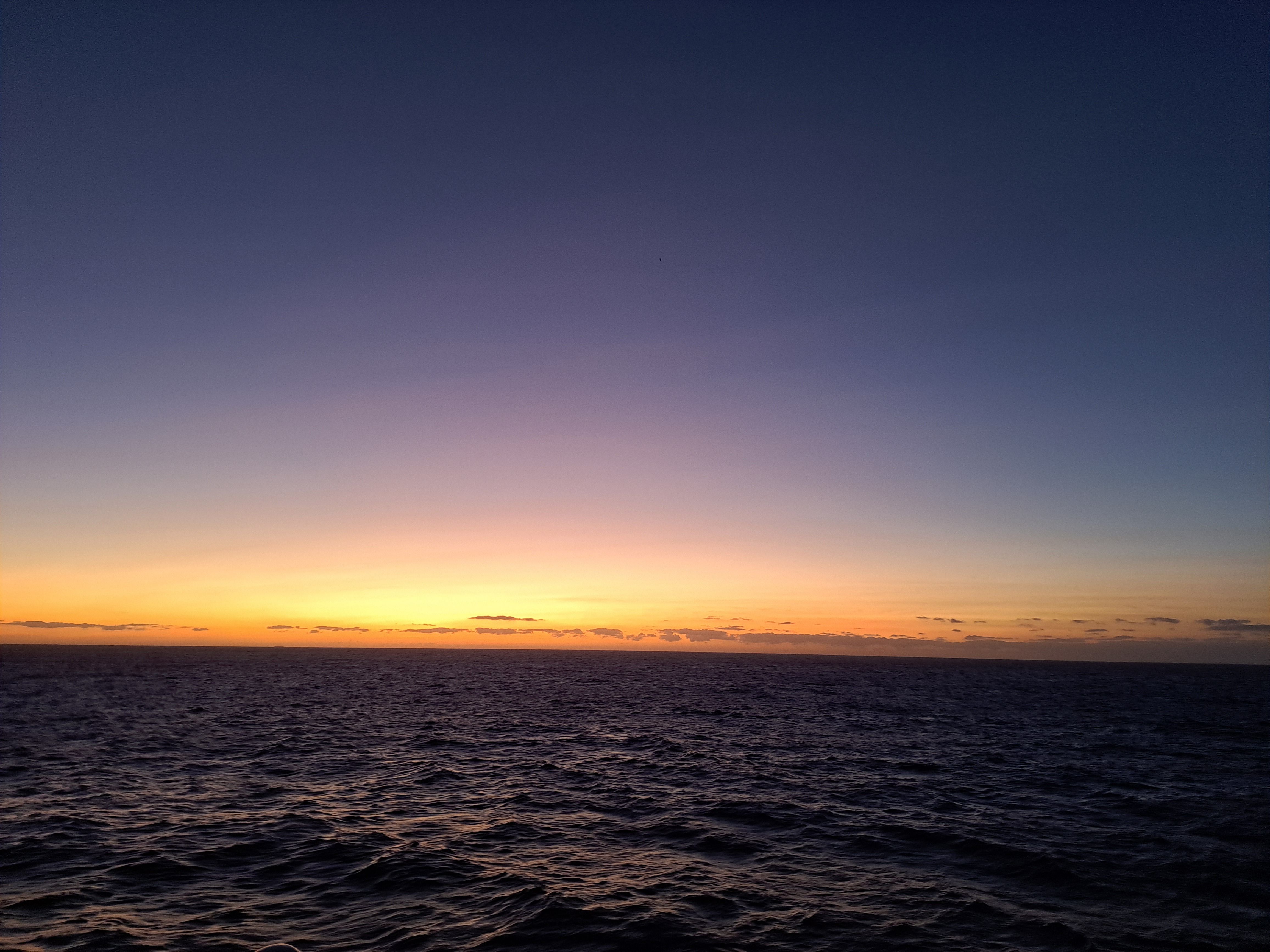 Serene ocean sunset with a vibrant gradient sky, perfect for travel and nature lovers.