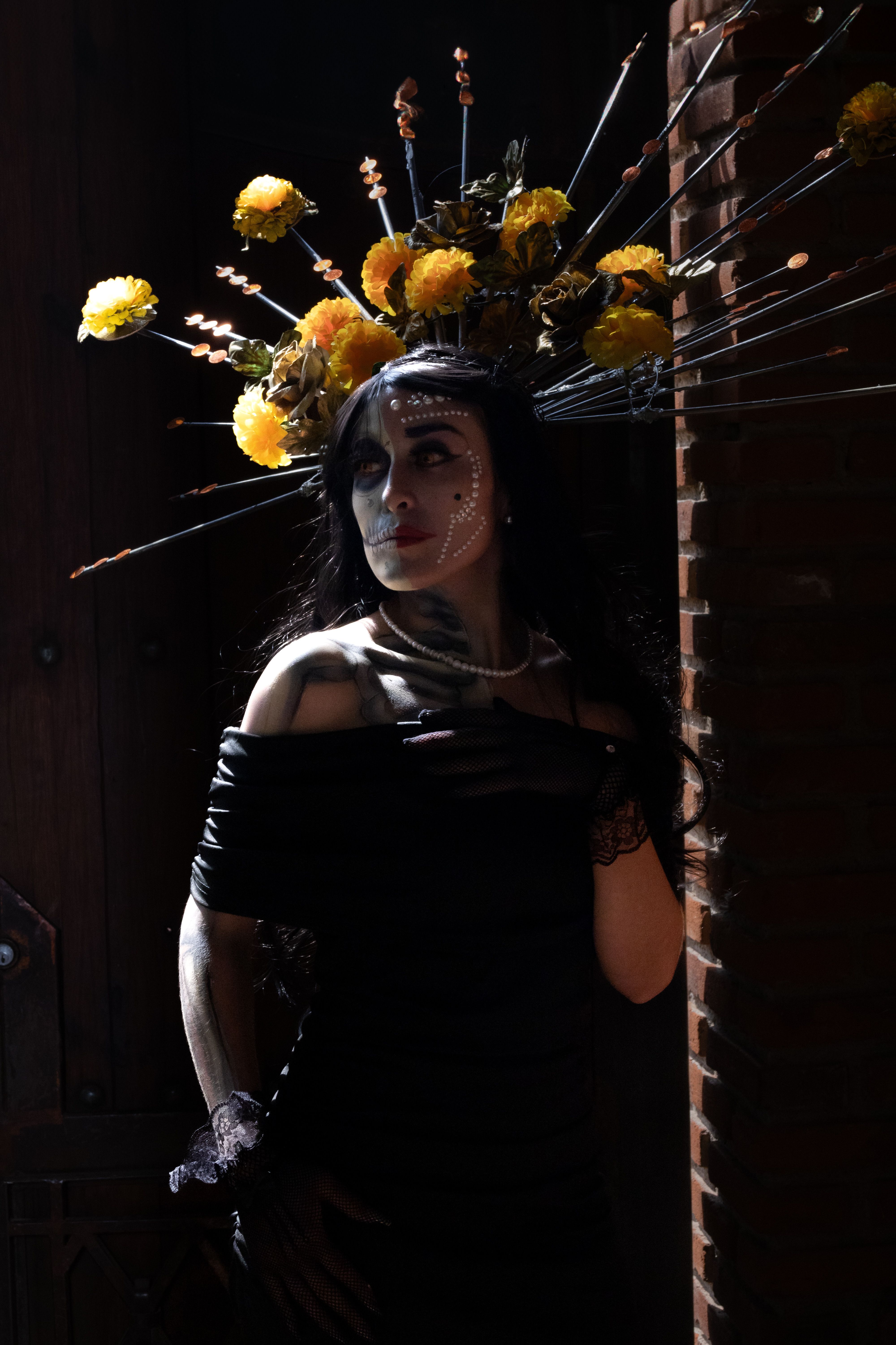 A woman in black and gold with flowers on her head · Free Stock Photo