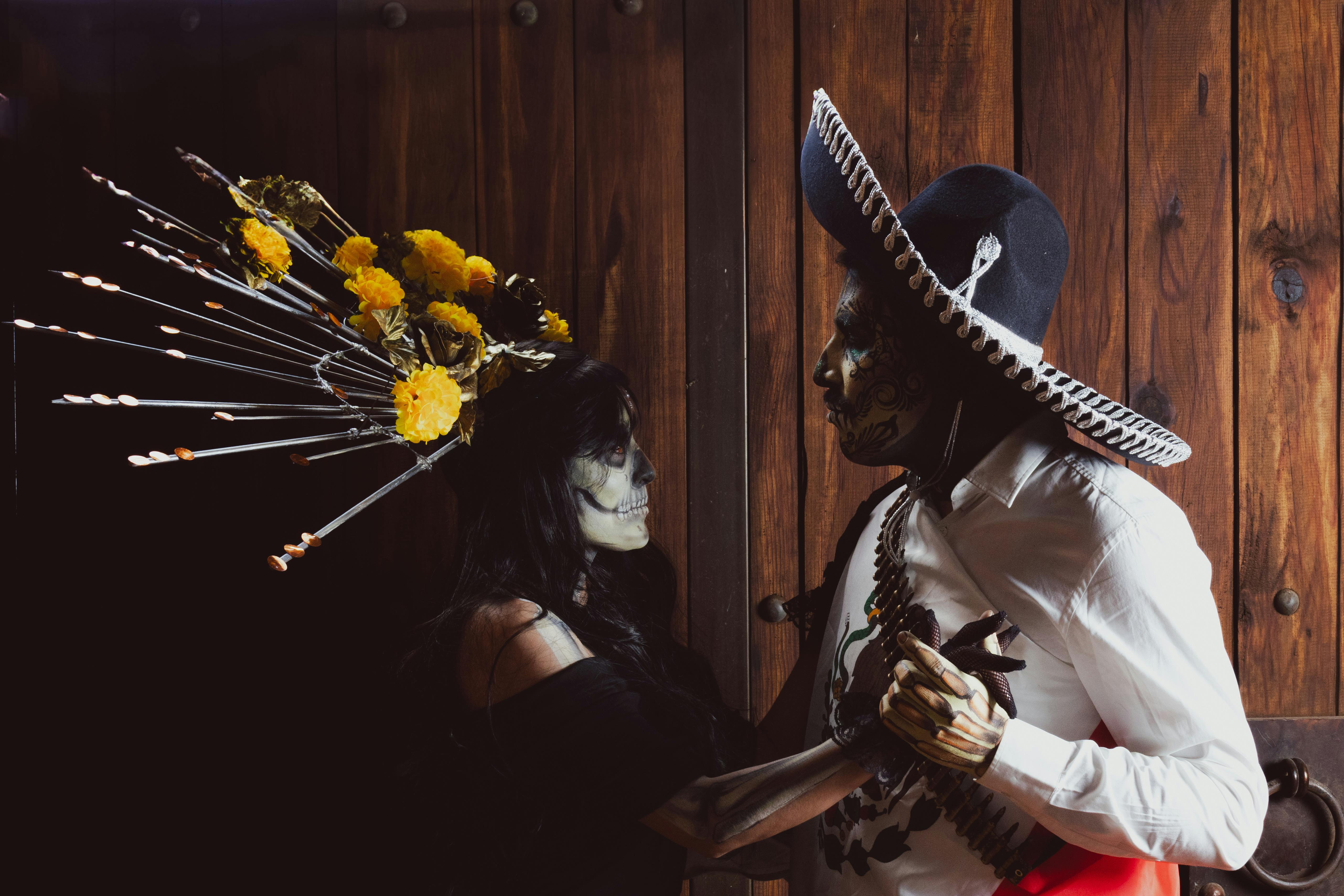 a couple dressed in costumes with a skull and a flower