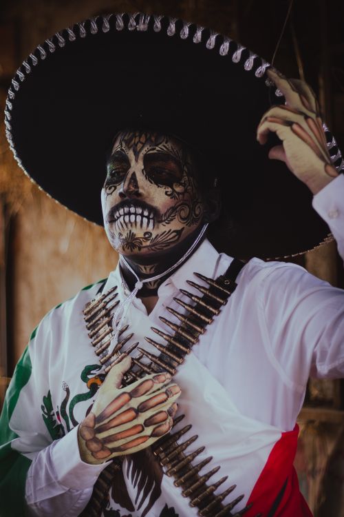 Free Man in a Día de los Muertos costume with skull makeup and traditional attire. Stock Photo