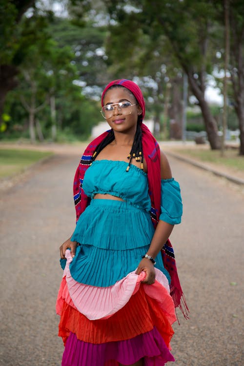 Selective Focus Photo of Smiling Woman in Multicolored Outfit Posing