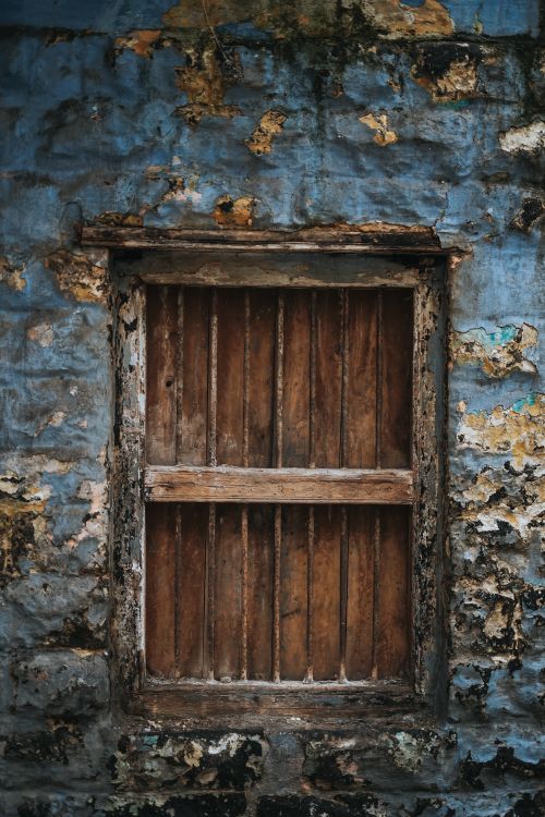 Free A rustic wooden window set in a weathered stone wall, capturing a vintage feel outdoors. Stock Photo