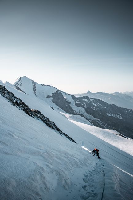A lone climber ascending a snowy mountain slope in Zermatt, Switzerland, capturing a sense of adventure and determination.