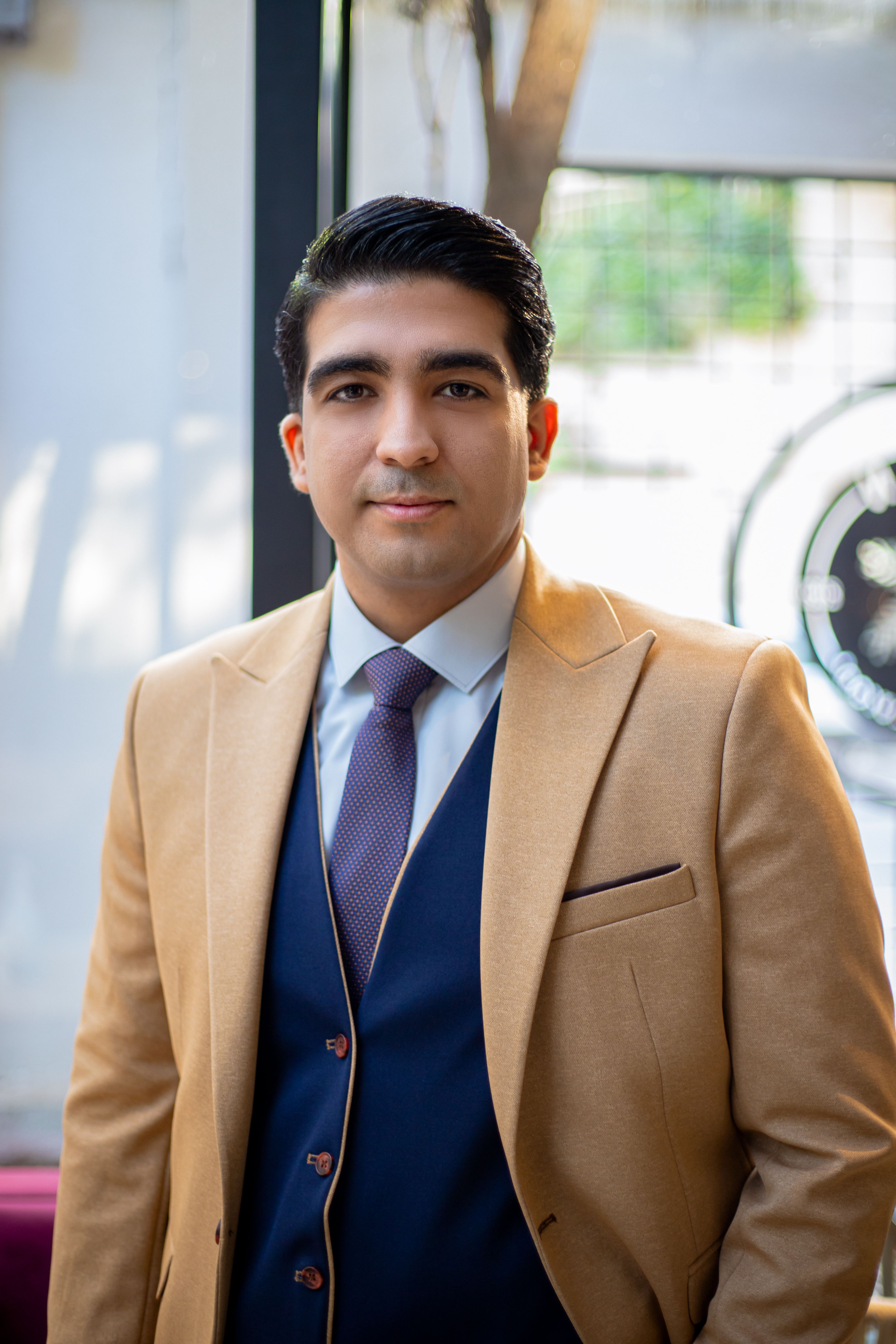 Confident man wearing suit and tie indoors, perfect for business concepts.