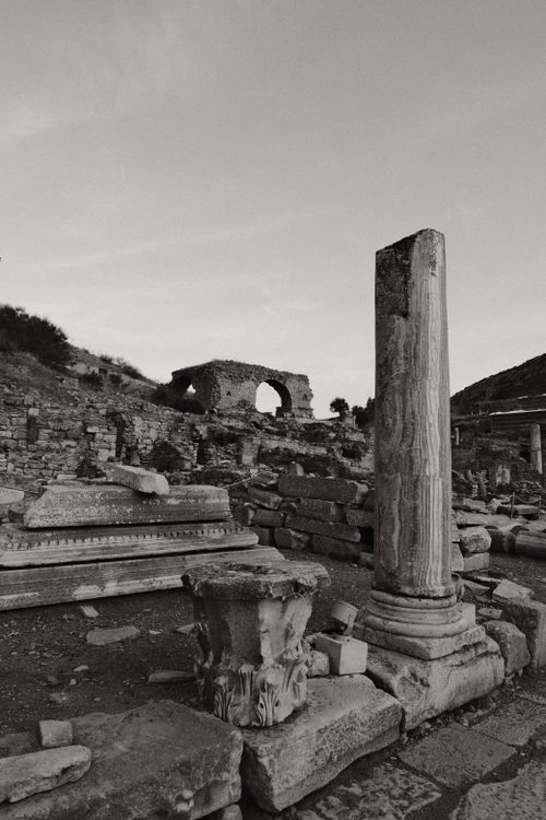 Free Black and white view of ancient stone ruins with columns under a dusky sky. Stock Photo