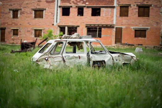 A Broken, Abandoned Car Standing on a Field 