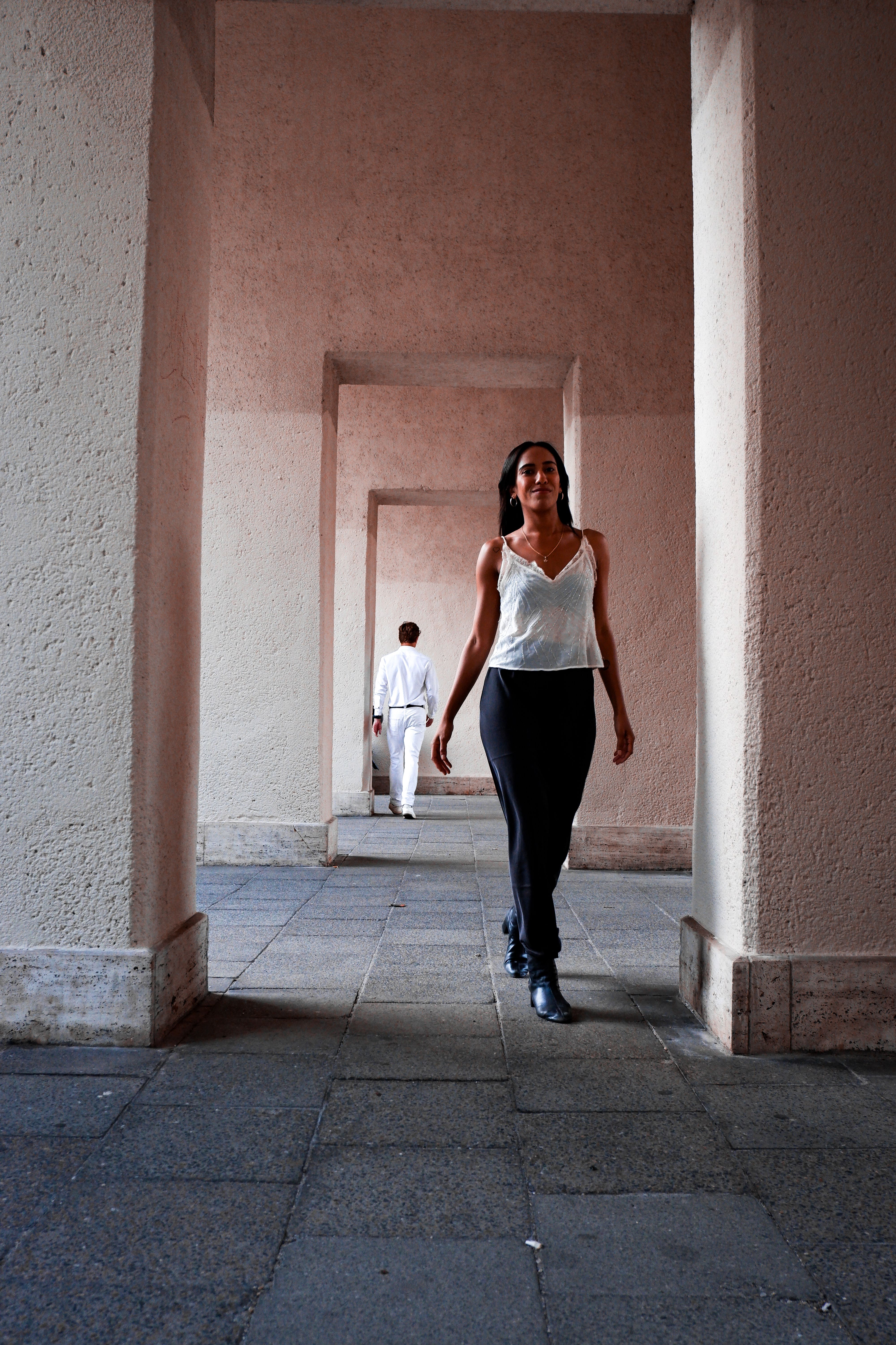 Elegant woman in urban corridor, embodying modern fashion and confidence.