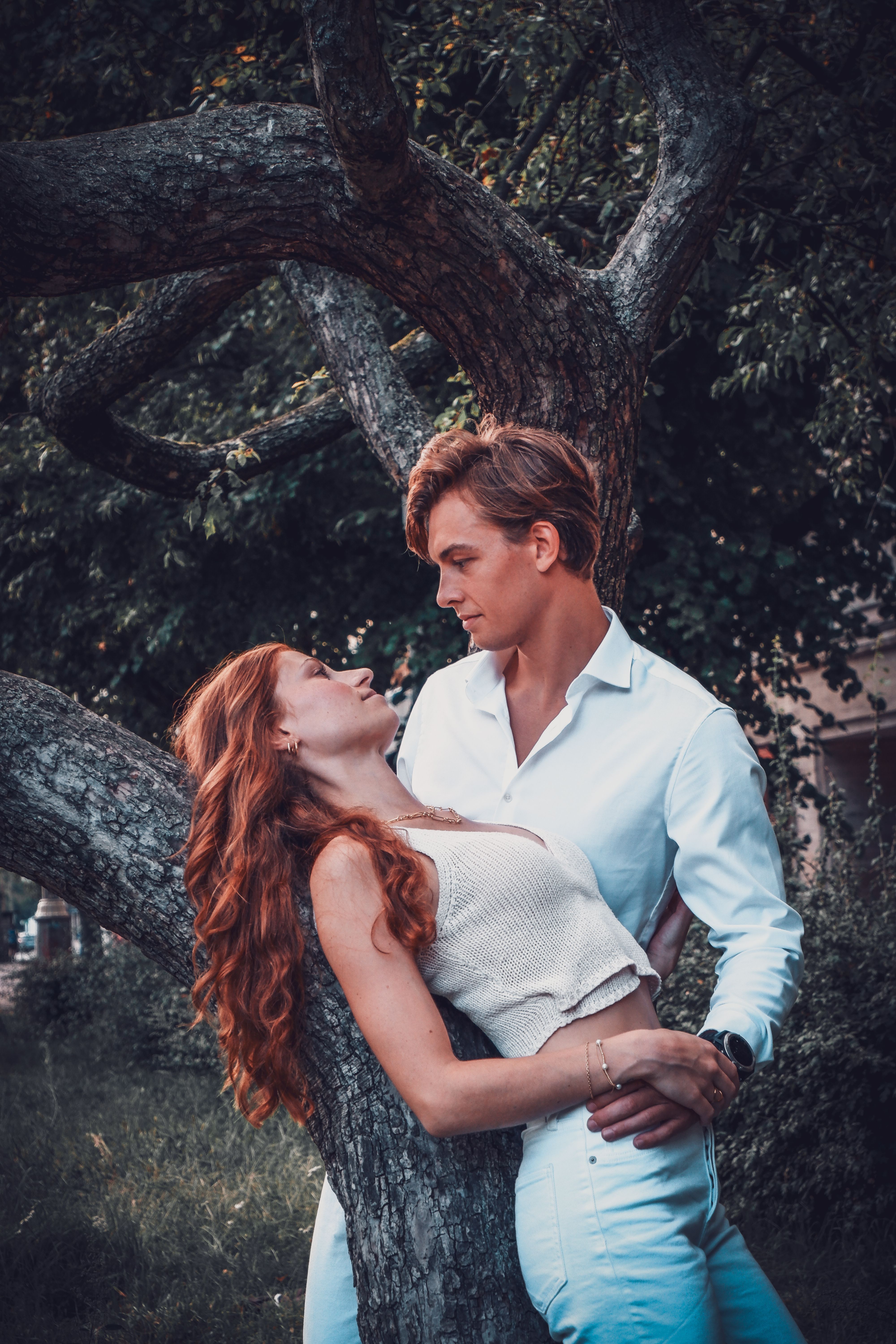 A Young Couple Posing by the Tree in a Park · Free Stock Photo