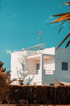 A modern white house bathed in sunny skies, capturing the essence of Ibiza.