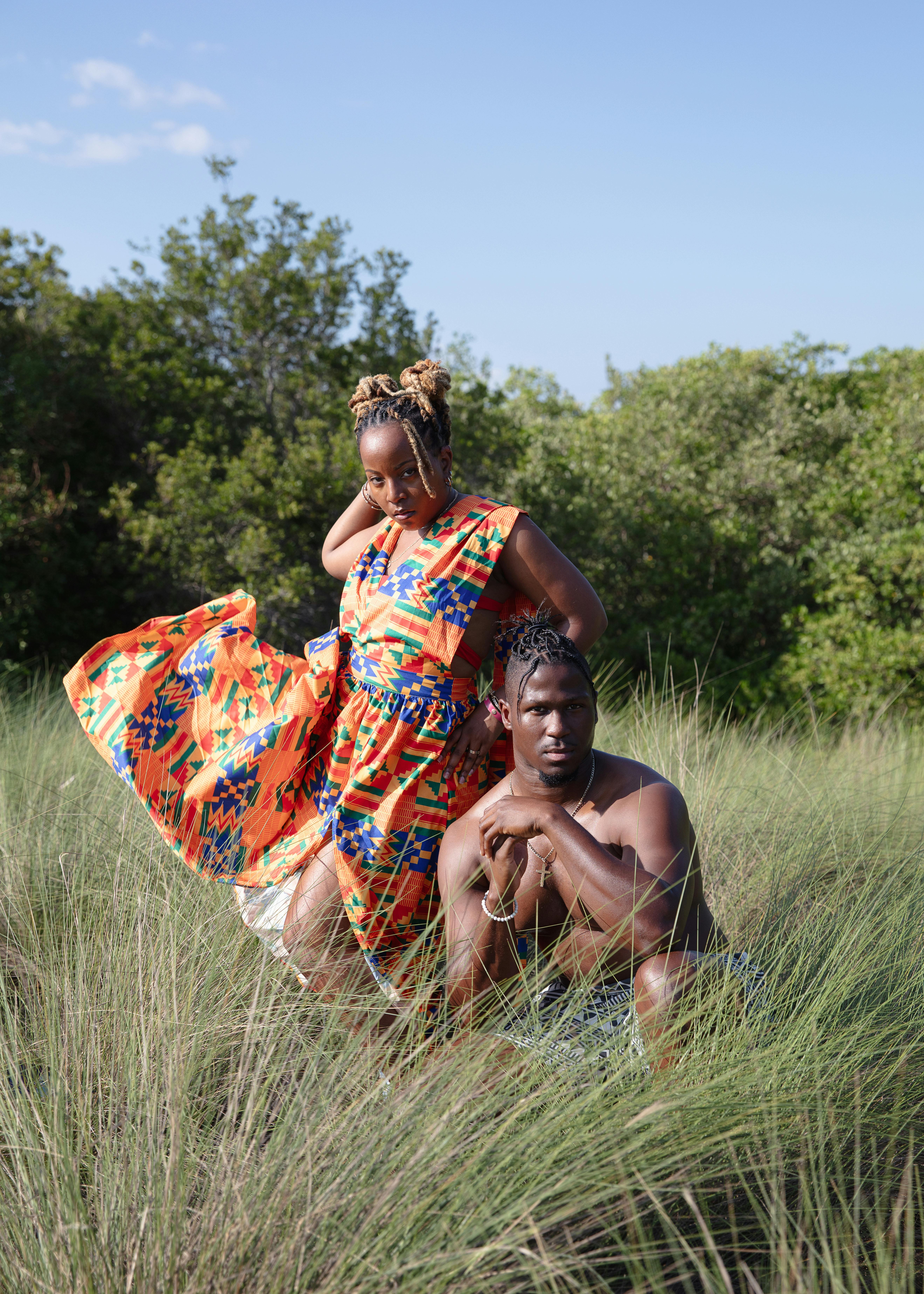 a man and woman are standing in tall grass